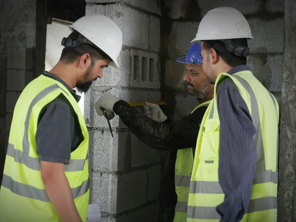 Engineers measuring a block wall
