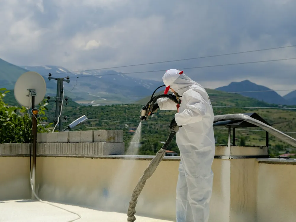 Insulation being sprayed on a concrete roof